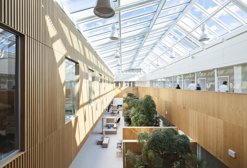 Indendørs atrium med frodig beplantning i det fælles område. Foto