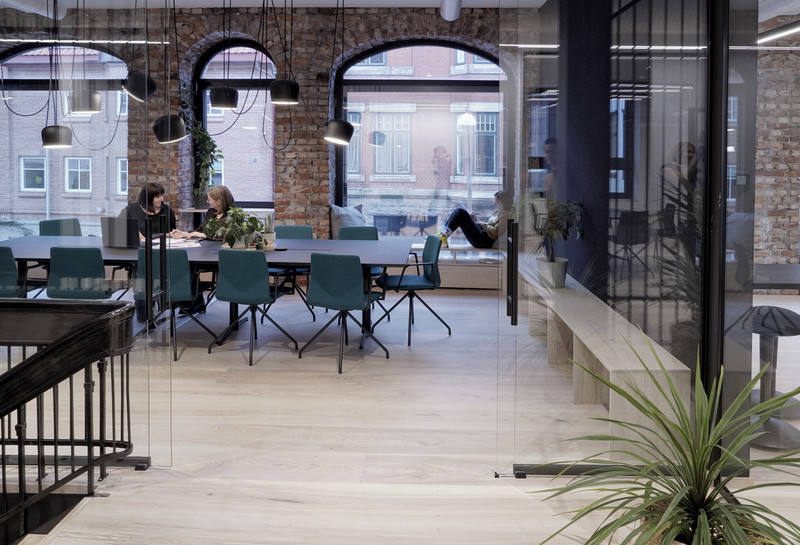 Large meeting room with long table, brick and arched windows. Photo