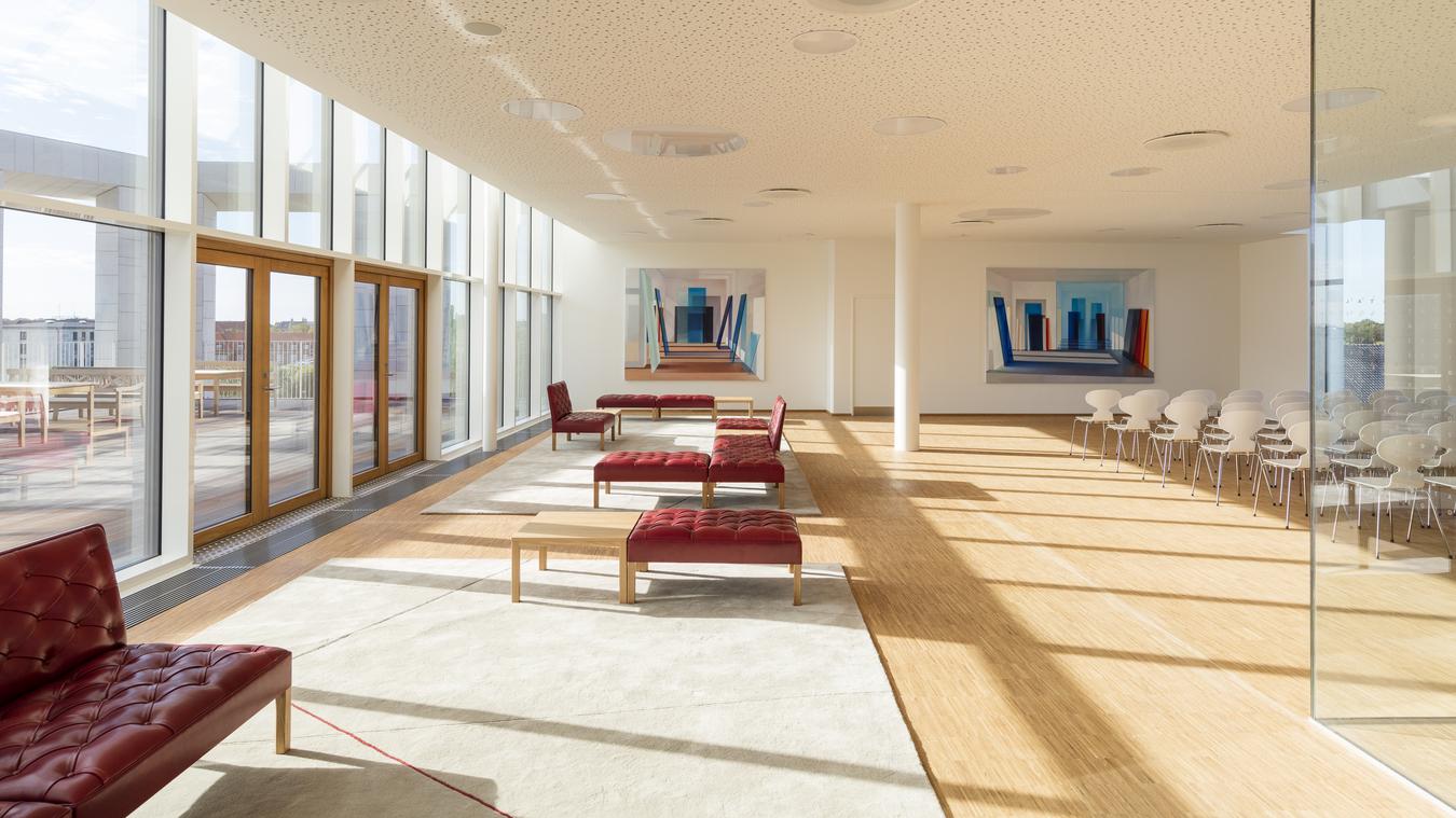 Meeting room with red seating and exit to the roof terrace. Photo