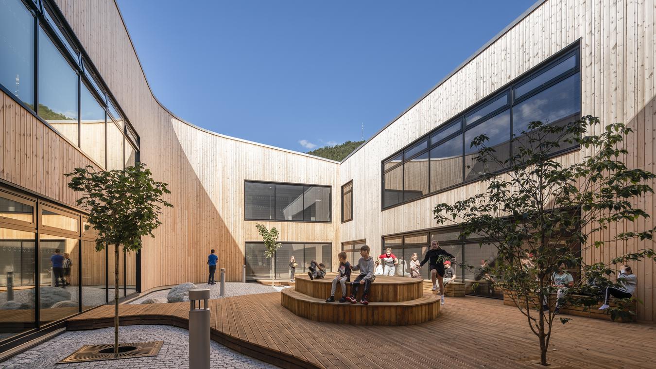 Atrium in wood creates a sheltered patio for play. Photo