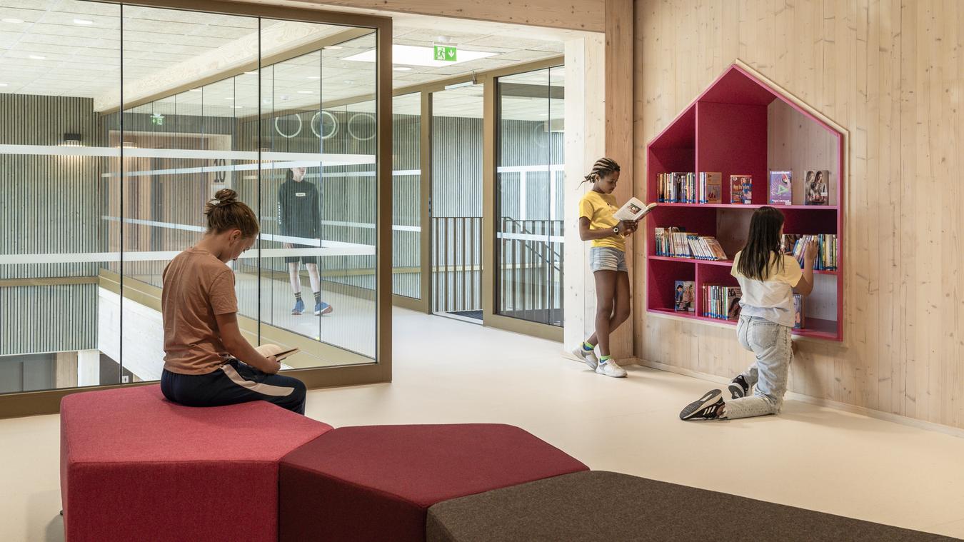 Library in glass and wood materials with crisp color contrasts. Photo