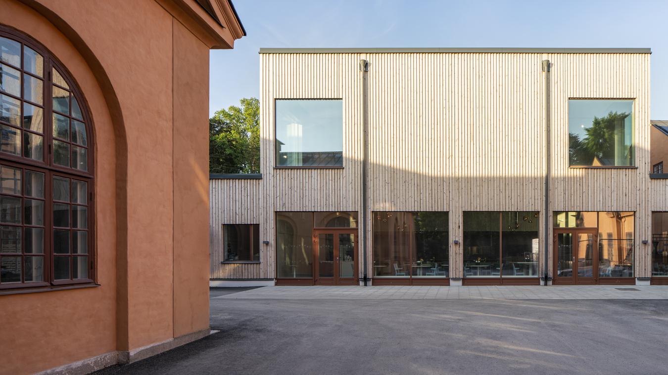 Old brick building and modern wooden buildings. Photo