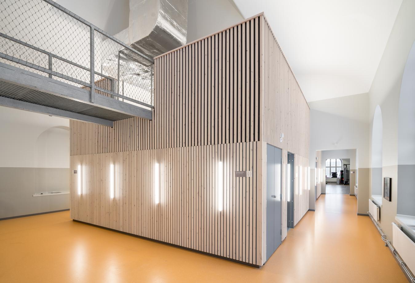 Corridor with wooden pillars, light walls and orange floor. Photo