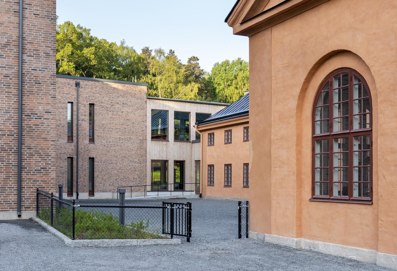 Ulike arkitektoniske uttrykk på fasade. Teglstein, tre og mur. Foto