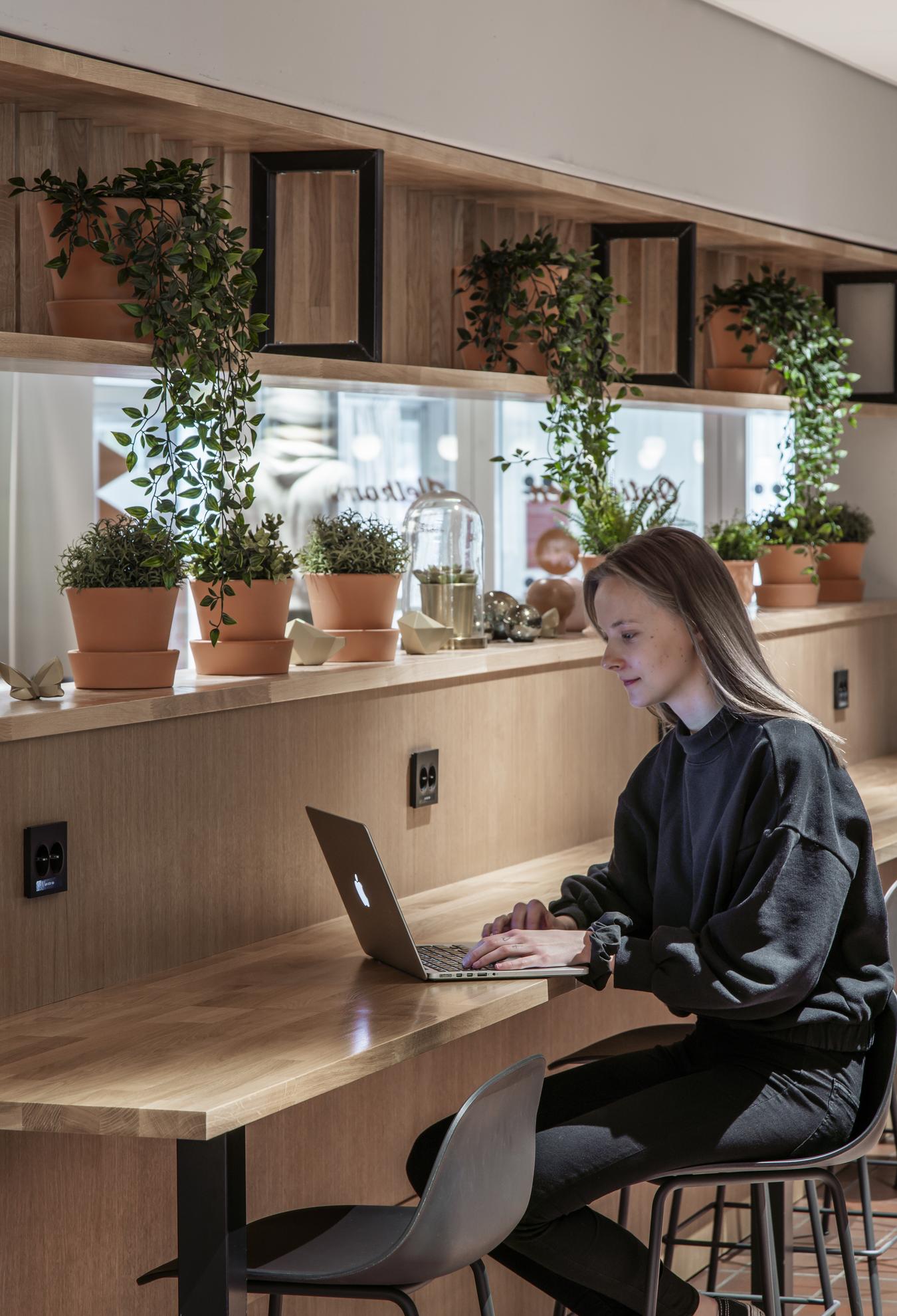 Person som arbetar på PC i matsalsområdet. Foto